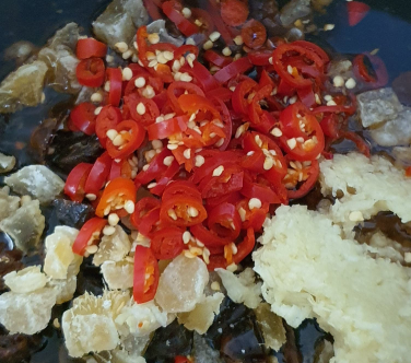 image of chillis and other ingredients being added to pot